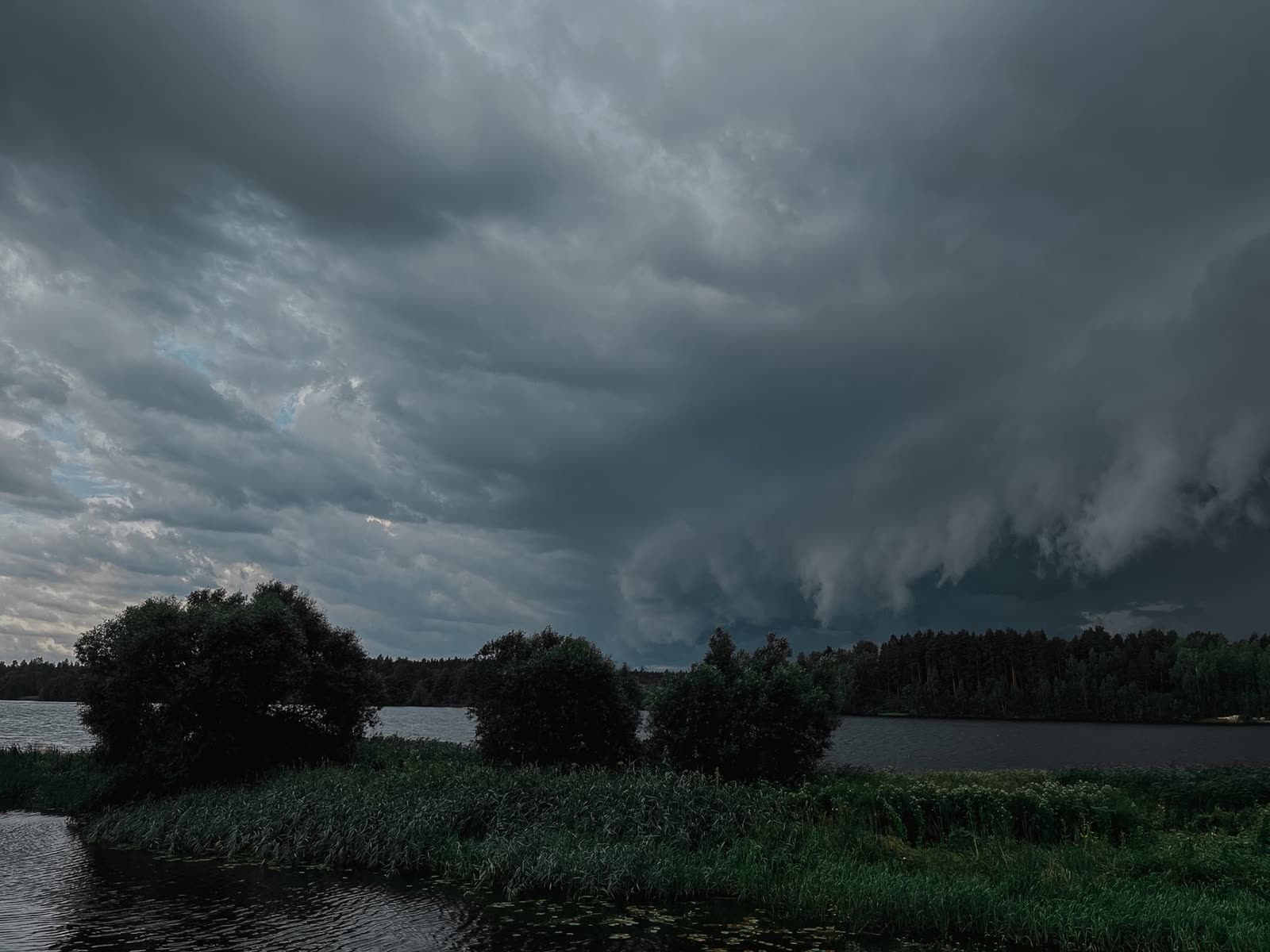 anglers in a small boat on a calm lake at sunrise / family sitting on a lake dock on a warm morning / dark storm clouds building over a southern lake in the afternoon
