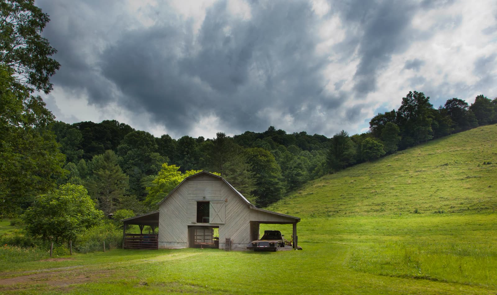 old wooden barn under dark clouds