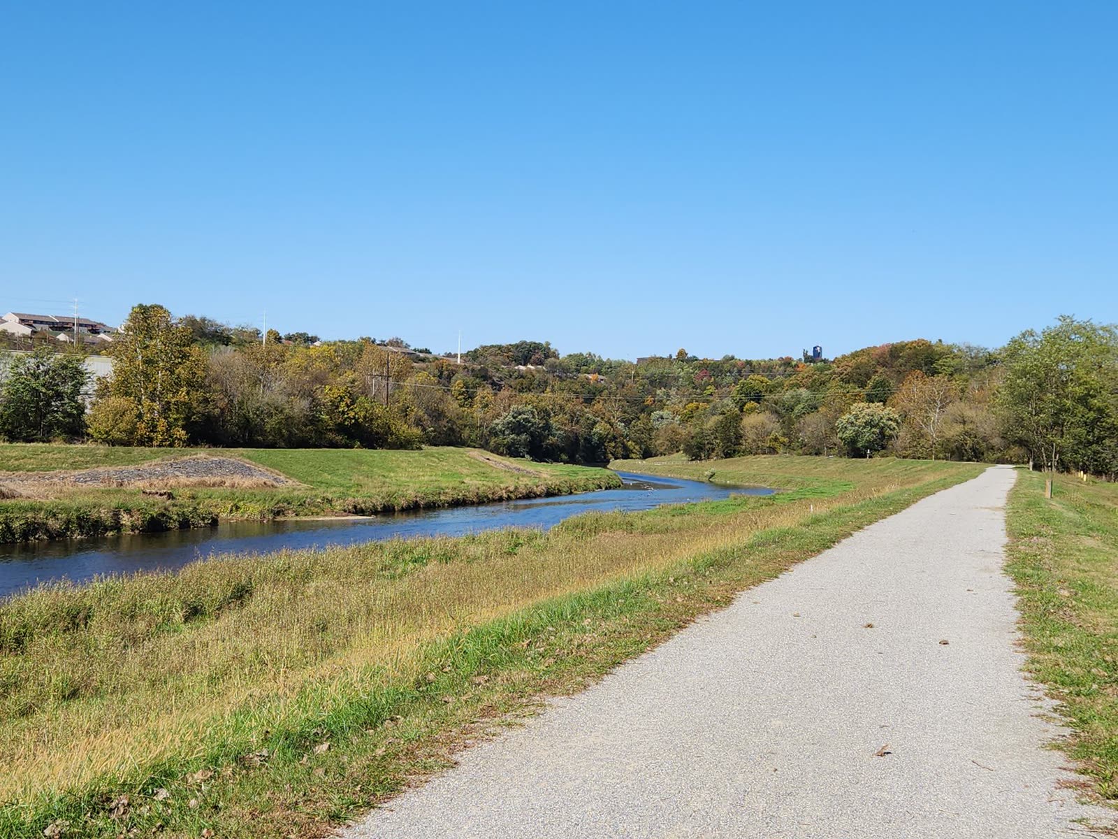 people walking on a riverside trail under clear autumn skies / hurricane tracking map on a laptop screen at a kitchen table / calm reservoir water at sunrise with an empty wooden fishing dock