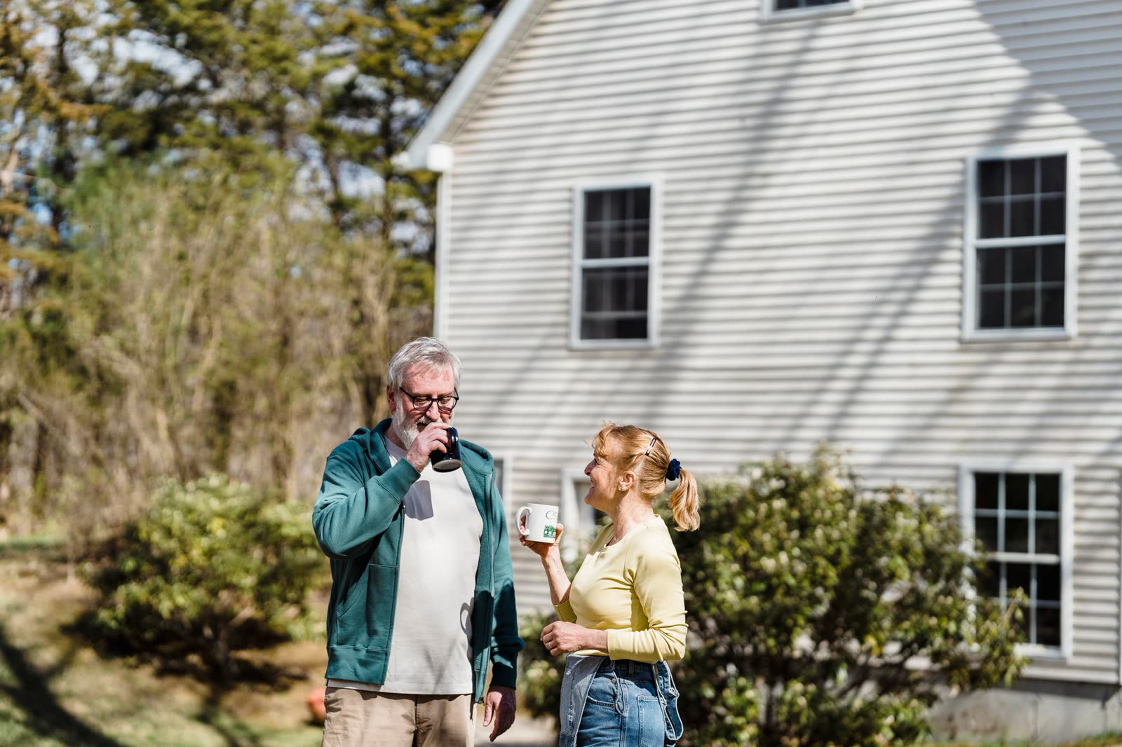 people in light jackets walking a riverside trail on a sunny fall morning / family drinking coffee on a porch on a crisp clear morning / golden sunrise over a small southern river town