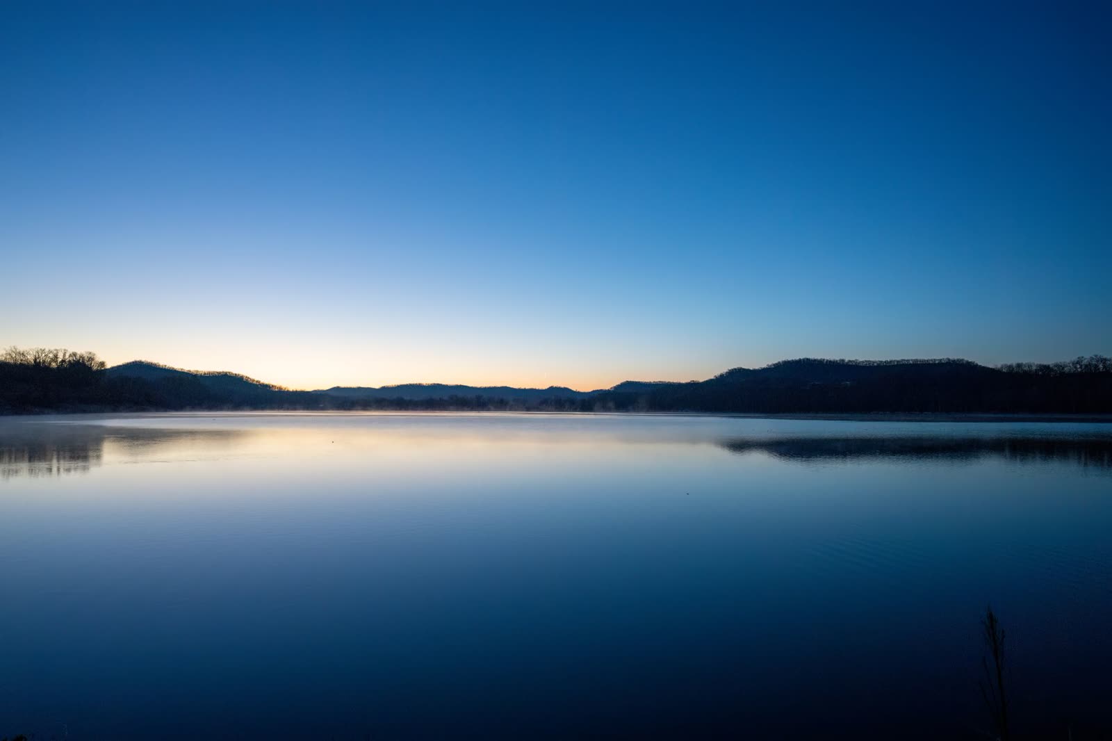 family sitting on a lake dock on a calm autumn morning / calm reservoir water at sunrise in the rural South / satellite view of a quiet ocean with scattered clouds